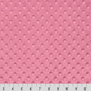 May include: Pink fabric with a textured polka dot pattern. The fabric is soft and plush, making it ideal for blankets, pillows, and other home decor projects.