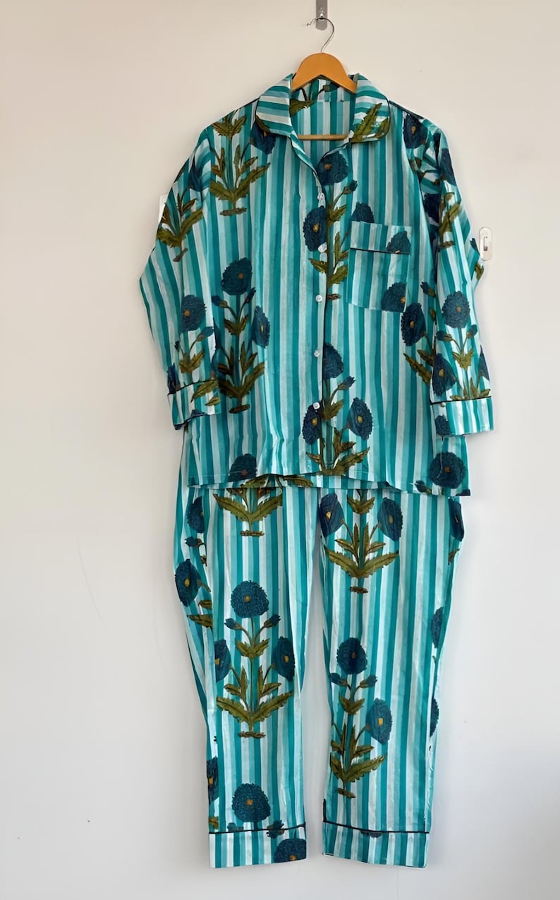 May include: A white ceramic mug with a black handle and the text "But First, Coffee" in a bold, black font. The mug is set against a blurred background, suggesting a cozy setting.