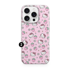 May include: A pink phone case featuring a repeating pattern of Hello Kitty faces, strawberries, and small white flowers. The case has a clear border and a camera cutout. The number "2" is printed in black on the lower left corner.