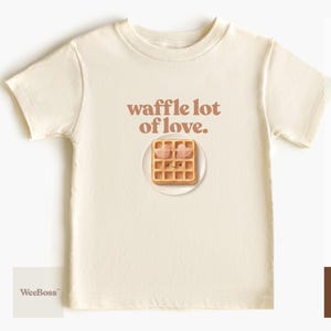 A cute, hand drawn waffle with heart toppings in soft colors - detailed view of a natural toddler t-shirt with product feature highlights - exclusive WeeBoss print detail