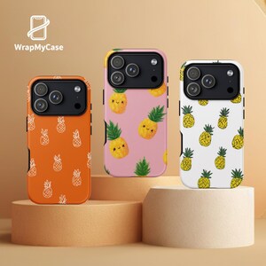 May include: Three phone cases with pineapple designs. One is orange with white pineapple outlines, another is pink with smiling pineapple illustrations, and the third is white with yellow pineapples. The brand name "WrapMyCase" is visible.