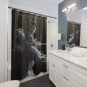 May include: A shower curtain featuring a detailed, futuristic cityscape design in shades of gray and blue against a dark background. The artwork depicts a complex structure with mechanical elements, creating a sci-fi aesthetic. The curtain is hanging in a bathroom setting.