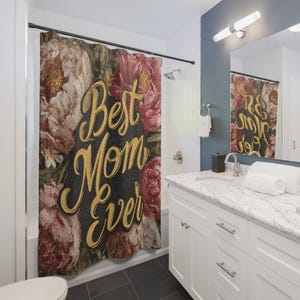 May include: A floral shower curtain with a black background and gold text that reads "Best Mom Ever." The curtain features a vintage-style design with pink and cream-coloured flowers.