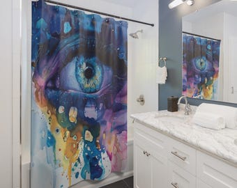 Peut inclure: Rideau de douche avec un gros plan sur un œil humain aux couleurs vives. L'iris est bleu, entouré de nuances de bleu, violet et jaune, créant un effet aquarelle artistique. Le rideau est installé dans une salle de bain.