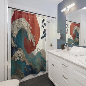 Könnte beinhalten: Ein Duschvorhang mit einem japanischen Wellenmuster, das eine große rote Sonne und Kalligraphie zeigt. Die Welle ist in Blau-, Weiß- und Grautönen gehalten und hat eine strukturierte Optik. Der Hintergrund ist cremefarben.