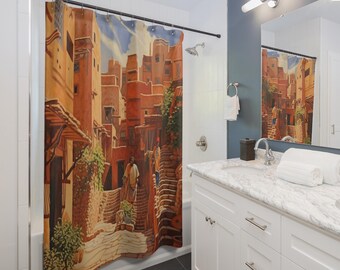 May include: A shower curtain featuring a detailed illustration of a Middle Eastern town with buildings in shades of orange and brown. The artwork depicts a street scene with figures, stairs, and greenery, creating a warm, inviting atmosphere. The curtain is hung in a bathroom setting.