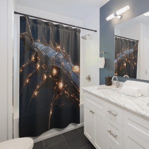 May include: A dark shower curtain with a detailed, abstract design. The artwork features a complex network of lines and glowing orbs in shades of blue, gold, and black. The curtain is hanging in a bathroom with white cabinets and a marble countertop.