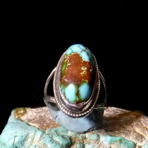 K&ouml;nnte beinhalten: Ein silberner Ring mit einem gro&szlig;en ovalen T&uuml;rkis-Stein, der in einer Zargenfassung sitzt. Der T&uuml;rkis hat eine sch&ouml;ne blaugr&uuml;ne Farbe mit brauner und gr&uuml;ner Matrix.