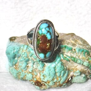 K&ouml;nnte beinhalten: Ein silberner Ring mit einem gro&szlig;en ovalen T&uuml;rkis-Stein. Der Stein hat eine braune Matrix und eine blaugr&uuml;ne Farbe.