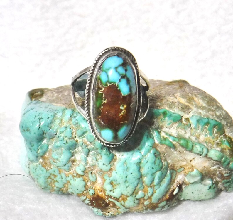 K&ouml;nnte beinhalten: Ein silberner Ring mit einem gro&szlig;en ovalen T&uuml;rkis-Stein. Der Stein hat eine braune Matrix und eine blaugr&uuml;ne Farbe.