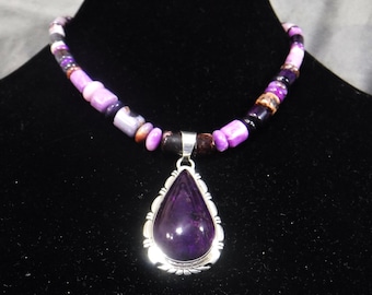 May include: A purple gemstone pendant necklace with a silver setting. The necklace is made with multi-colored beads.
