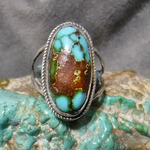 K&ouml;nnte beinhalten: Ein silberner Ring mit einem gro&szlig;en ovalen T&uuml;rkis-Stein. Der Stein hat eine braune Matrix und eine blaugr&uuml;ne Farbe.