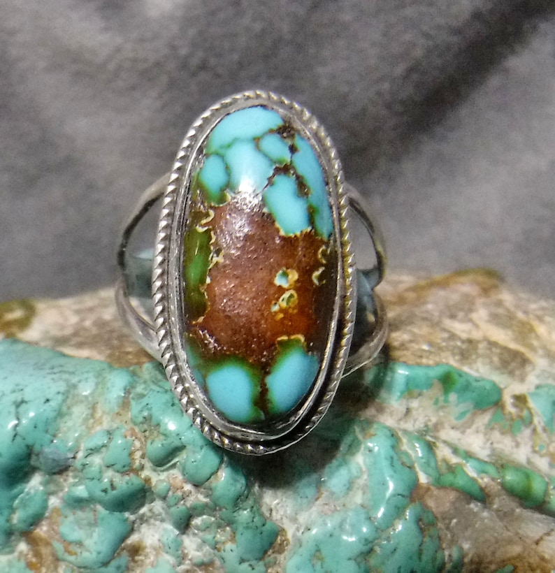 K&ouml;nnte beinhalten: Ein silberner Ring mit einem gro&szlig;en ovalen T&uuml;rkis-Stein. Der Stein hat eine braune Matrix und eine blaugr&uuml;ne Farbe.