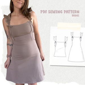 Peut inclure: Une robe taupe avec des bretelles à volants qui se nouent sur le dessus. À côté de la robe se trouve un papier carré blanc présentant un dessin au trait noir du modèle de robe et de haut, avec le texte PDF SEWING PATTERN DR001.