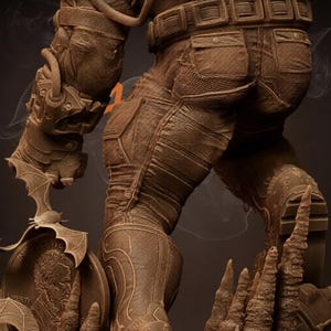 May include: A detailed brown statue of a figure in a textured suit with a utility belt and pockets. The statue has a bat-shaped emblem and a memorial with the text "In God We Trust" and a portrait.