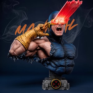 May include: A bust of Cyclops from the X-Men, featuring a blue and yellow costume. The figure has a red energy beam emanating from the eyes. The bust is mounted on a gray base with an X-Men logo. The word "MA" is written in orange.