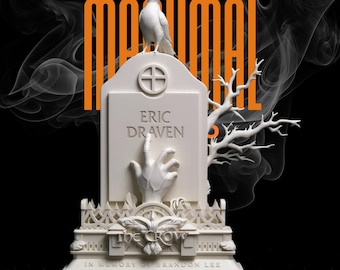 May include: A white tombstone sculpture with the name "Eric Draven" and a hand reaching out. A white crow sits atop the tombstone, with the word "maximal" in orange. The base reads "The Crow" and "In Memory of Brandon Lee."
