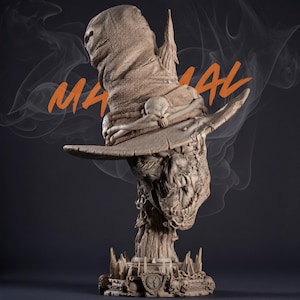 May include: A detailed sculpture of a scarecrow head and hat, with the word "MANUAL" in orange. The scarecrow has a burlap sack head covering and a wide-brimmed hat. The sculpture is in shades of tan and brown, with a dark background.