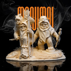 Könnte beinhalten: Eine detaillierte, cremefarbene Skulptur von drei Ewoks aus Star Wars. Die Figuren stehen auf einer grasbewachsenen Basis, eine hält einen Stab und eine einen Bogen. Das Wort "maqumai" steht in Orange über den Figuren.