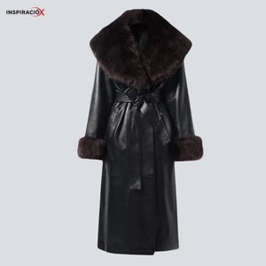 May include: A long black leather coat with a wide, dark brown fur collar and matching fur cuffs. The coat features a belted waist and a classic, elegant design. The coat is a stylish outerwear piece.