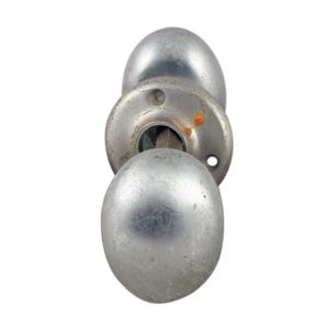 Könnte beinhalten: Ein silberner Türknauf mit einem runden Griff und einer runden Basis. Der Knauf hat eine leicht abgenutzte Oberfläche.