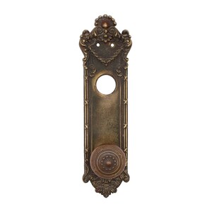 May include: Ornate brass door hardware with a decorative knob and a keyhole cutout. The hardware has a vintage, antique look.