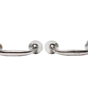 May include: Two silver metal drawer pulls with rounded edges and a curved shape.