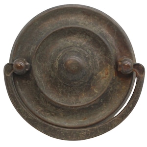 Puede incluir: Un tirador de armario vintage redondo de latón con un anillo decorativo y un asa curva. El tirador tiene un acabado desgastado y envejecido.