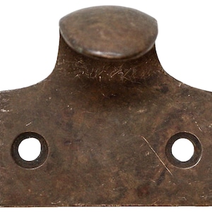 Puede incluir: Un elevador de ventanilla de bronce vintage con dos agujeros para tornillos. El elevador tiene una parte superior redondeada y una base plana.