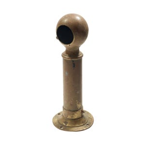 May include: A vintage brass curtain rod holder with a round top and a cylindrical body. The holder has a circular opening at the top and a circular base with screw holes. The brass has a warm, aged patina.