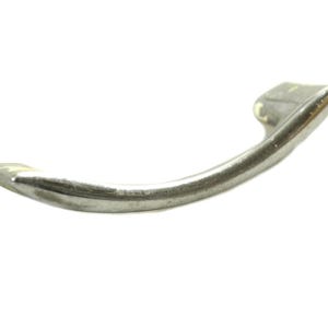 May include: A silver-toned metal cabinet handle with a curved design.