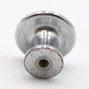 May include: A silver metal knob with a round top and a threaded base.