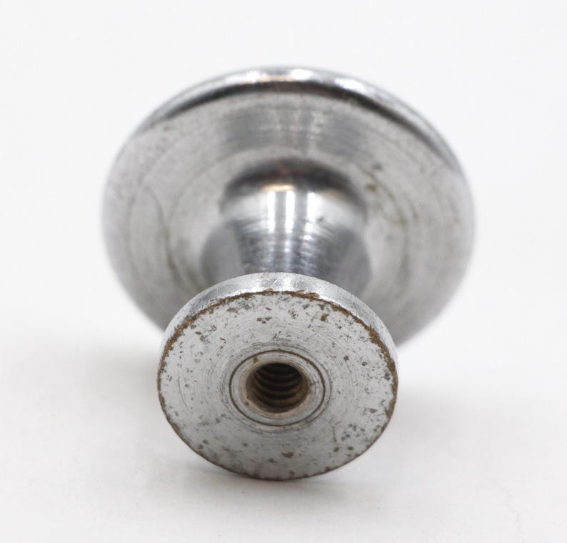 May include: A silver metal knob with a round top and a threaded base.