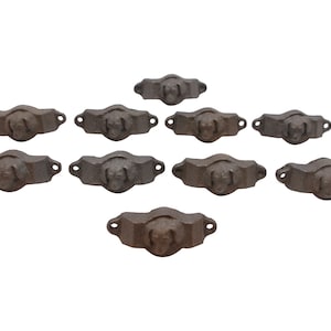 Puede incluir: Diez tiradores de cajón de hierro fundido con un diseño de cabeza de perro. Los tiradores son de color marrón oscuro y tienen un acabado rústico.