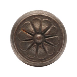 Può includere: Un pomello rotondo in metallo color bronzo con un design floreale stilizzato in rilievo.