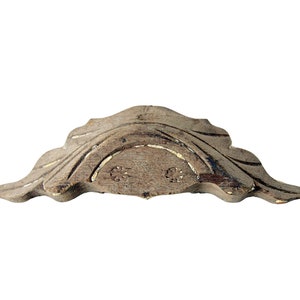 May include: A carved wooden drawer pull with a leaf design. The pull is a light brown color and has a slightly distressed finish.