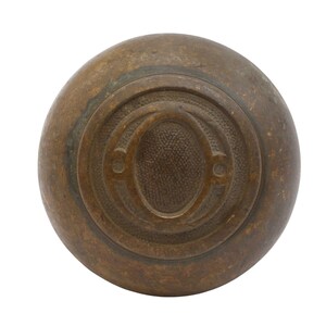 May include: A brown, round, metal bowling ball with a raised, embossed letter "O" on the surface.