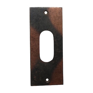 Puede incluir: Una placa de puerta rectangular de metal con un recorte para la cerradura. La placa es una mezcla de tonos negros y cobrizos.