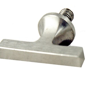 Könnte beinhalten: Ein silberner T-förmiger Griff mit einer Gewindeschraube oben. Der Griff ist aus Metall und hat eine glatte, polierte Oberfläche.