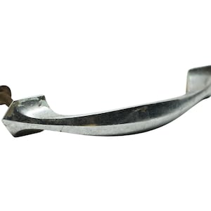 May include: A silver-toned metal cabinet door handle with a curved design and a pointed end. The handle has a single screw hole.