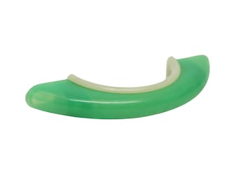 May include: A green and white plastic ring with a smooth, rounded surface. The ring is designed to be used as a finger exerciser.