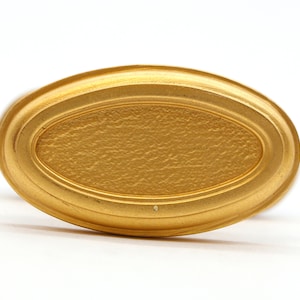 May include: A gold oval-shaped decorative object with a textured surface.