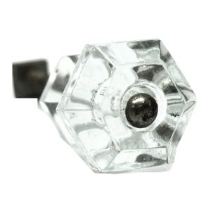 May include: A clear glass cabinet knob with a hexagonal shape and a silver metal base.