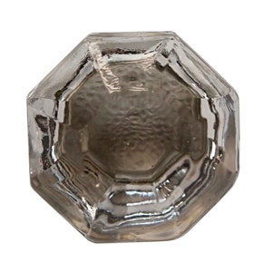 May include: A clear glass octagonal bottle stopper with a textured surface.