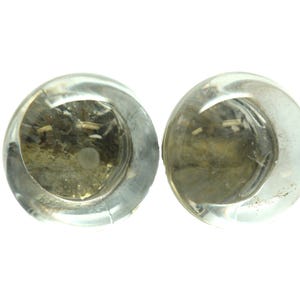 May include: Two clear glass paperweights with a cloudy, speckled interior.