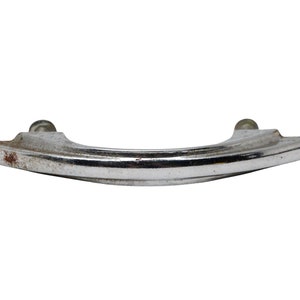 May include: A silver-toned metal cabinet pull with a curved design. The pull has a slightly worn finish.