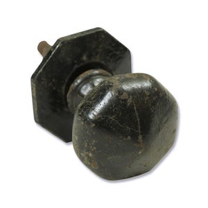 May include: A black metal door knob with a hexagonal shape and a worn finish.