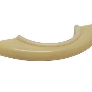 May include: A cream-colored plastic handle with a rounded shape and a smooth surface.