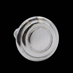 May include: Silver cabinet knob with a circular design and a raised center.