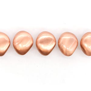 Op de afbeelding: Vijf gladde, ovale kralen in rosé goud.